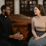 Ekumenizm a nawrócenie: czy dialog wyklucza głoszenie Chrystusa? Kapłan i kobieta rozmawiają na kościelnej ławce o wierze i dialogu