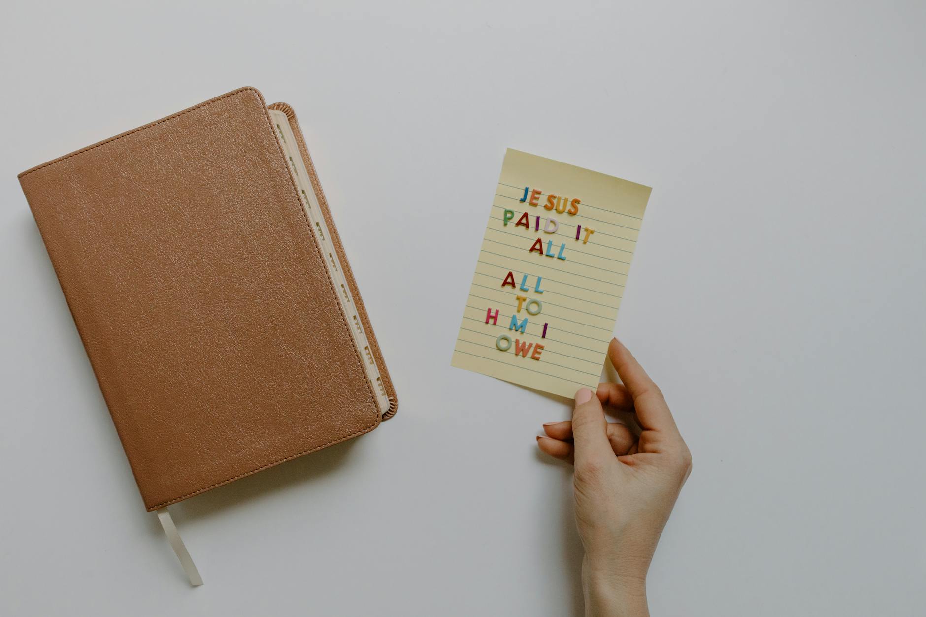 Otwarta Biblia z karteczką z napisem Jezus spłacił wszystko