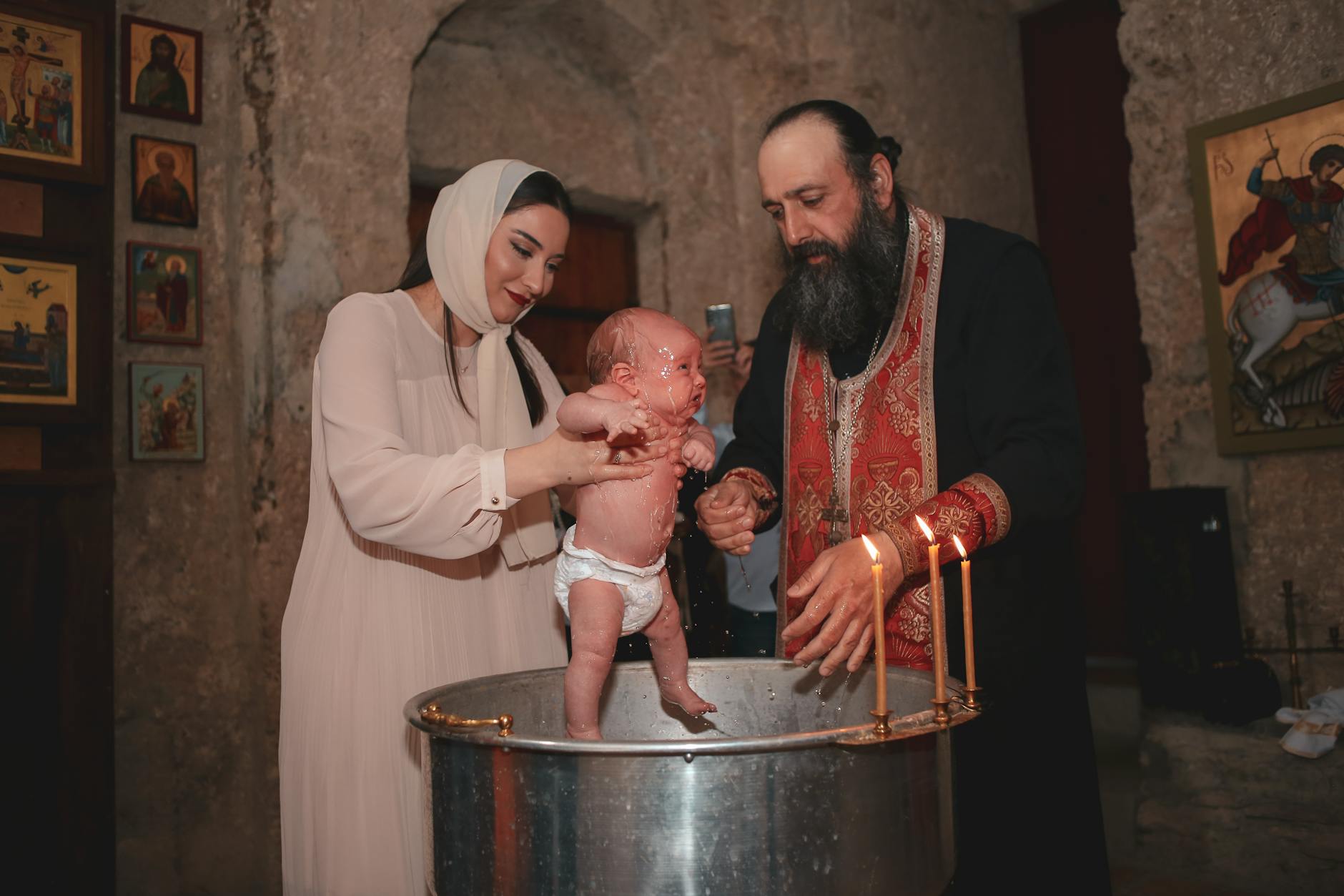 Kapłan z rodziną podczas prawosławnego chrztu w kościele