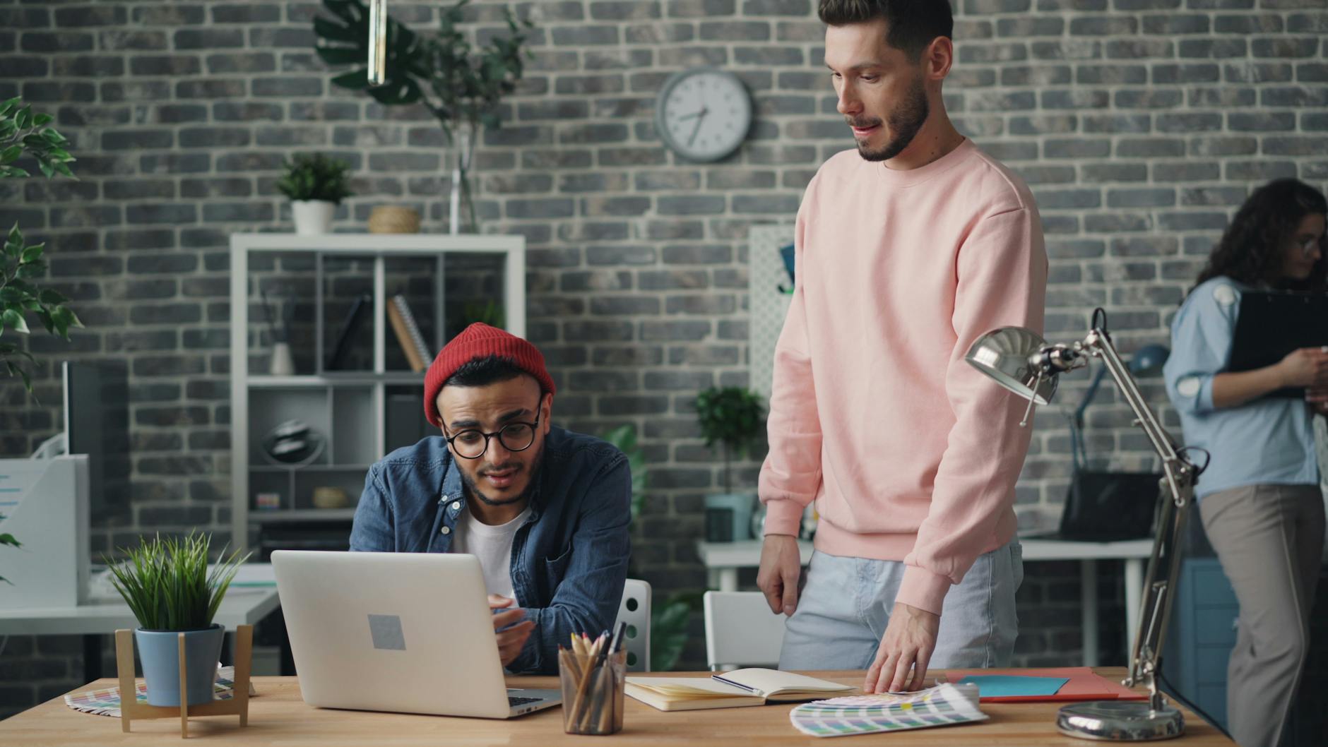 Młodzi dorośli dyskutujący przy biurku w nowoczesnym biurze