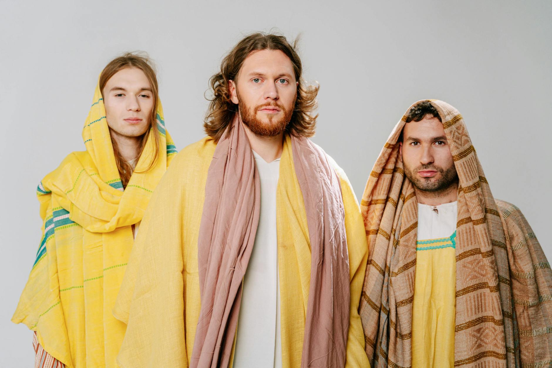 Trzej mężczyźni w szatach biblijnych podczas sceny religijnej indoors