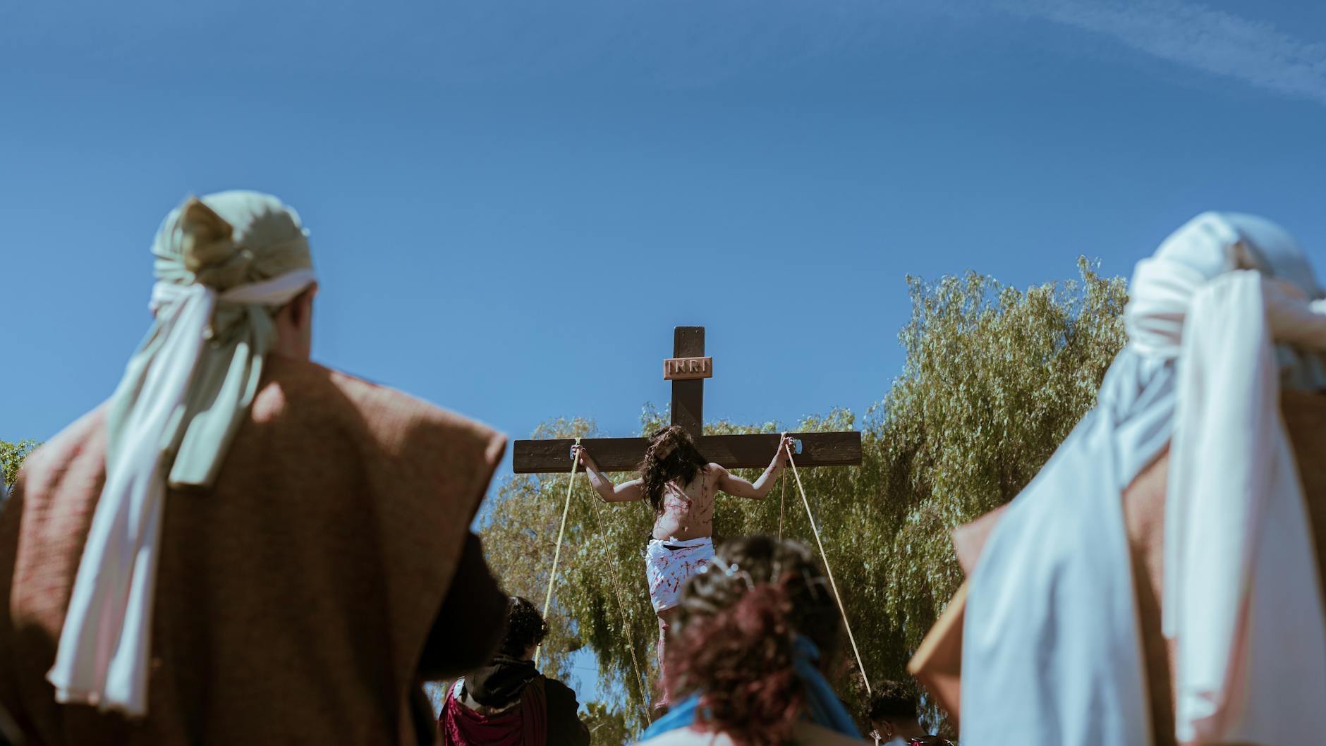 Ukrzyżowanie Jezusa na tle błękitnego nieba wśród zgromadzonych ludzi