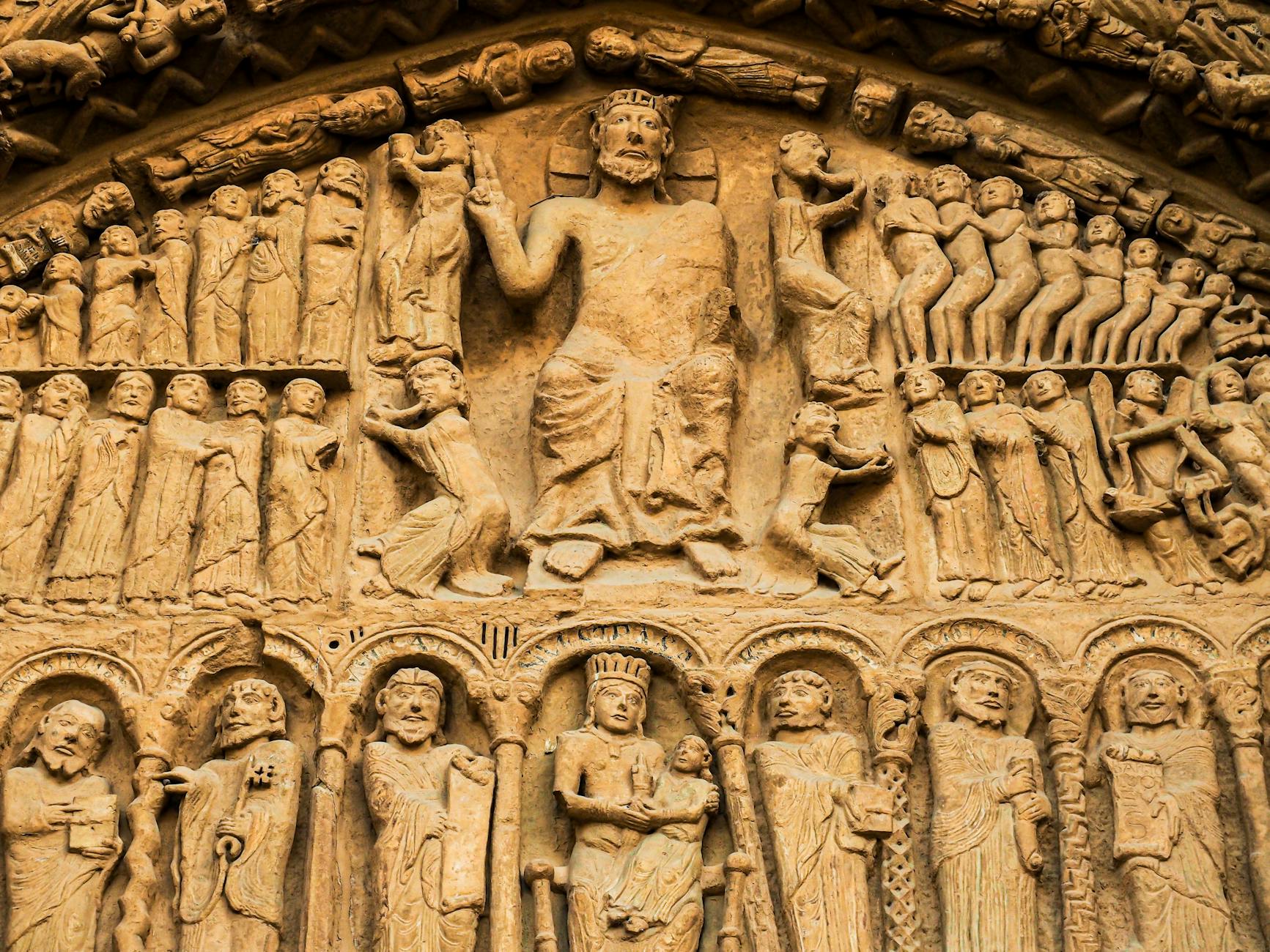 Kamienne rzeźby postaci na ścianie starego kościoła