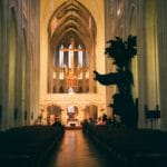 Dlaczego Kościół ma tyle świąt i wspomnień? Klucz do kalendarza liturgicznego Wnętrze gotyckiej katedry z ołtarzem i podświetlonym krzyżem