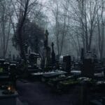 Uroczystość Wszystkich Świętych: czy to święto smutne czy pełne nadziei? Zamglony zimowy cmentarz z licznymi nagrobkami i krzyżami