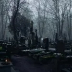 Zamglony zimowy cmentarz z licznymi nagrobkami i krzyżami