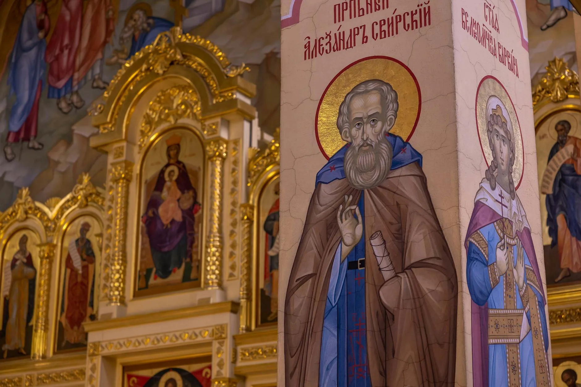 Zdobione wnętrze kościoła z religijnymi freskami i złotymi dekoracjami