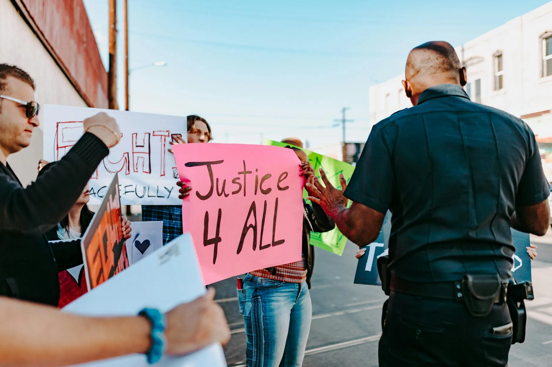 Policjanci rozmawiają z demonstrantami trzymającymi transparenty