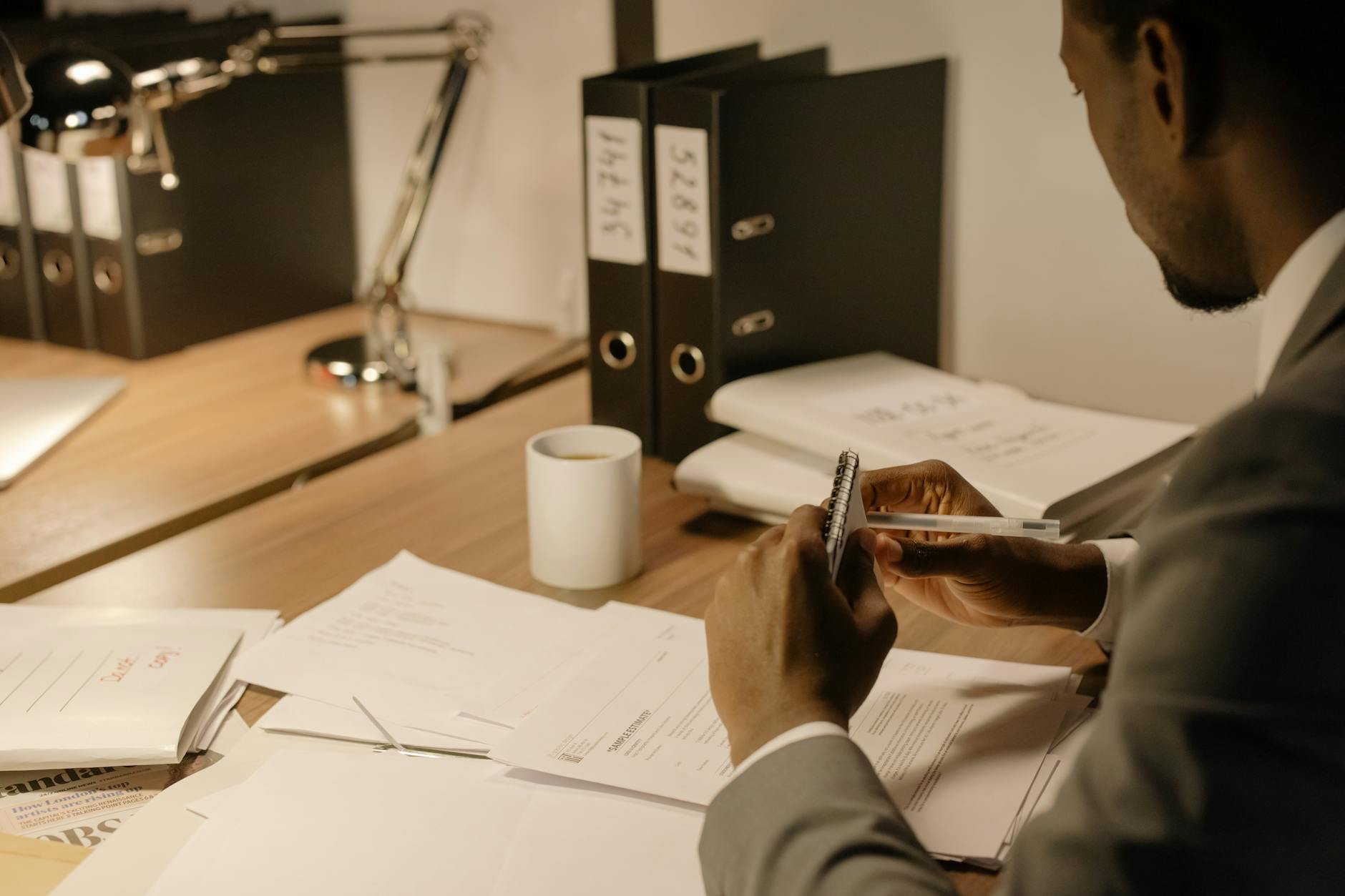 Jak modlić się w pracy i nie zgubić skupienia Mężczyzna w garniturze skupiony przy biurku nad dokumentami