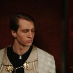 Celibat w praktyce: o samotności, przyjaźni i dojrzałej bliskości duchownych Spokojny ksiądz w konfesjonale w półmroku kościoła