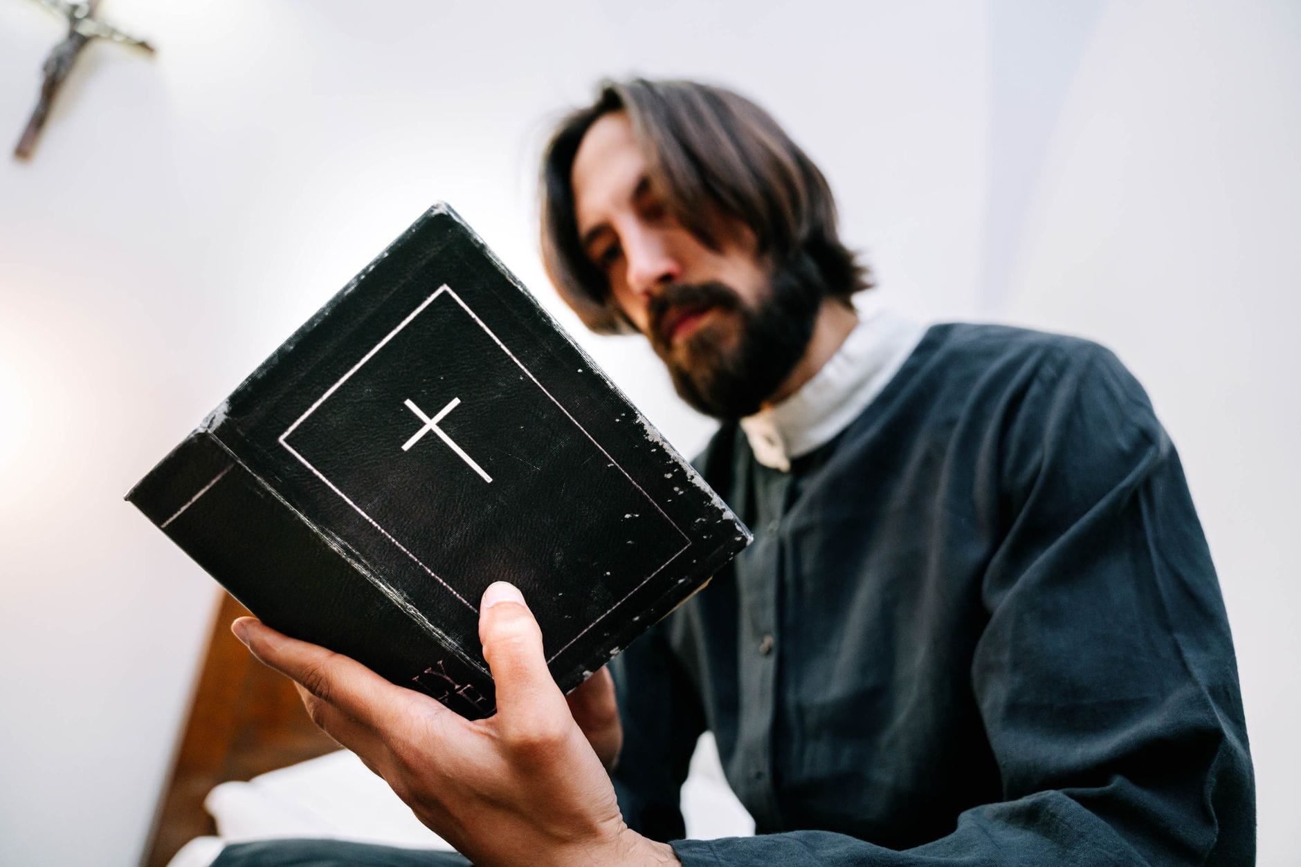 Jak chrześcijanin ma reagować na ideologie: rozeznanie bez lęku i agresji Kapłan czyta Biblię w ciszy, pogrążony w modlitwie i skupieniu