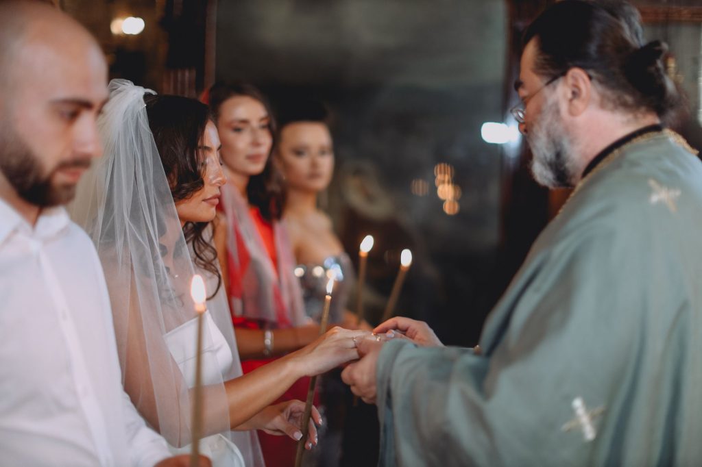 Para wymienia obrączki podczas prawosławnej ceremonii ślubnej z księdzem